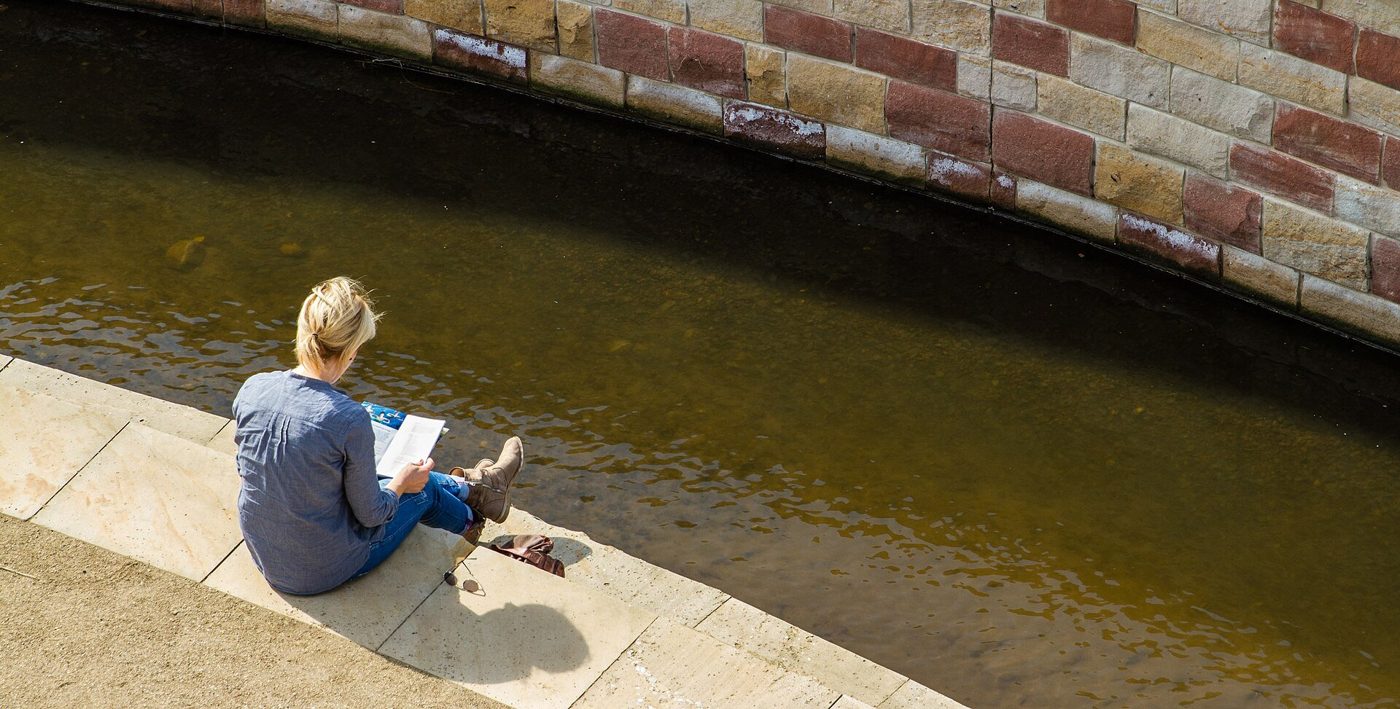 A reader absorbed in a novel outdoors