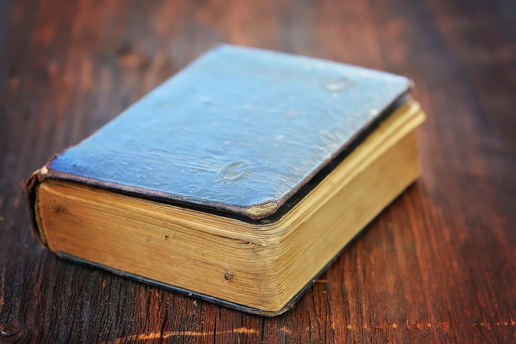Aged leather-bound book resting on a wooden table