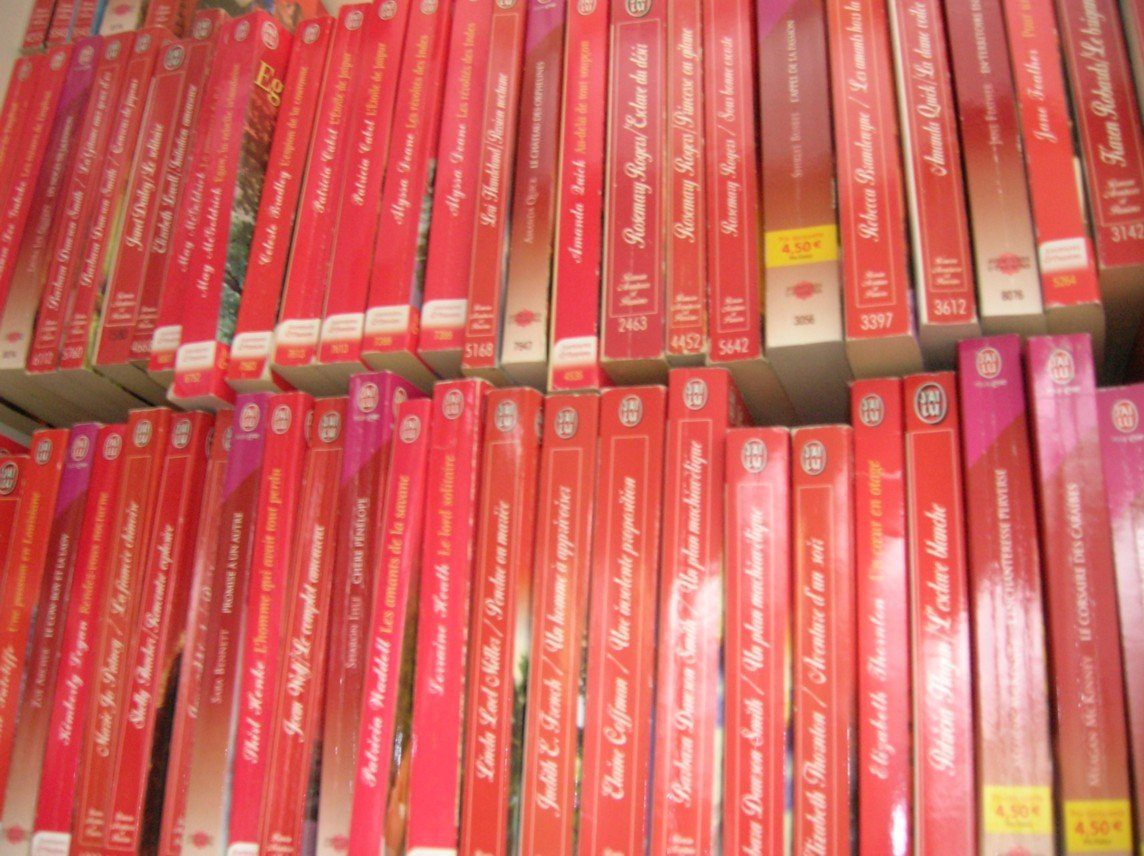 Rows of red and pink romance paperbacks on a shelf