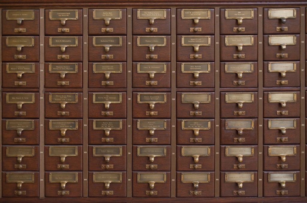 A wall of wooden library card catalog drawers