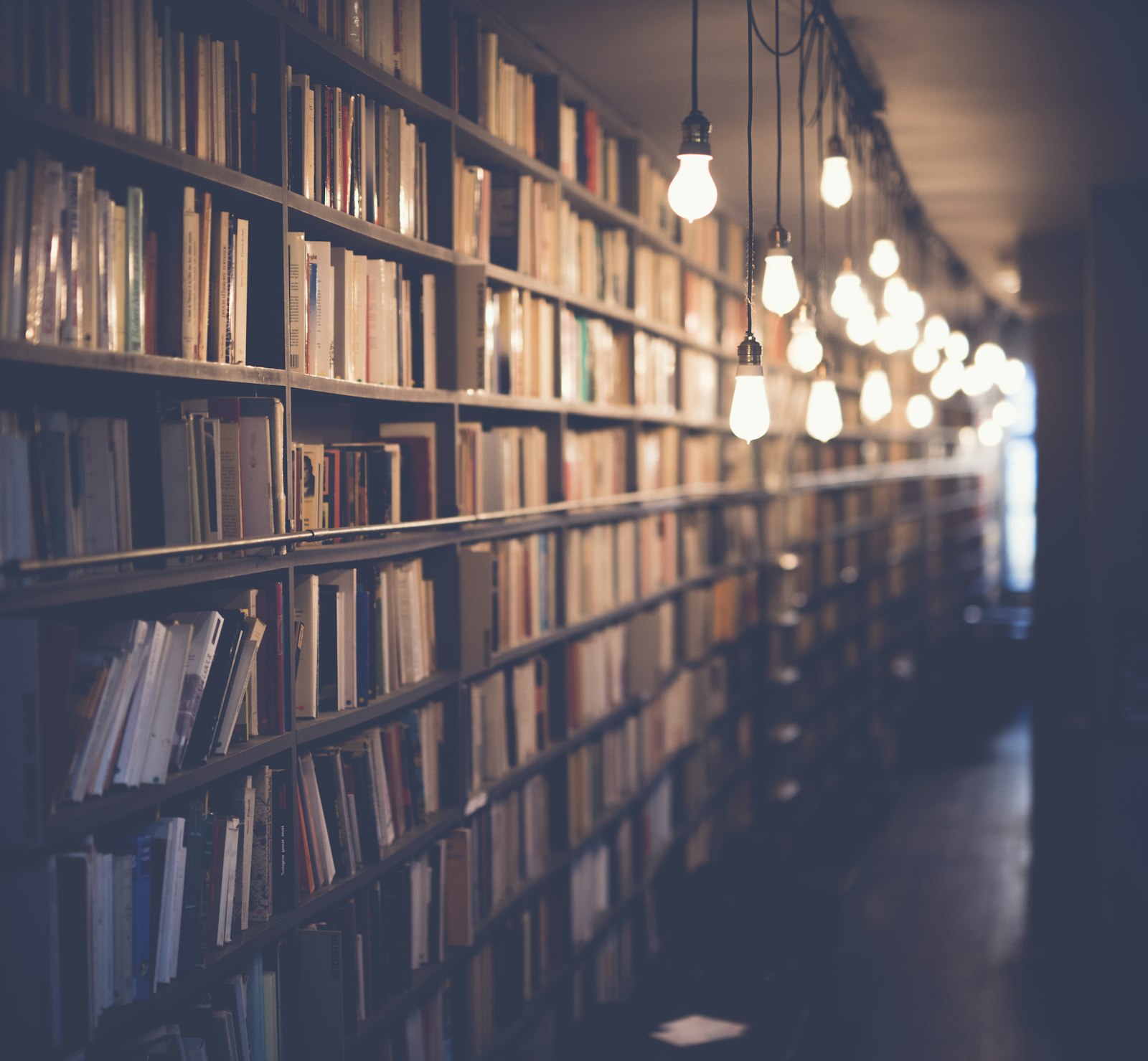 Lit library corridor lined with shelves of books